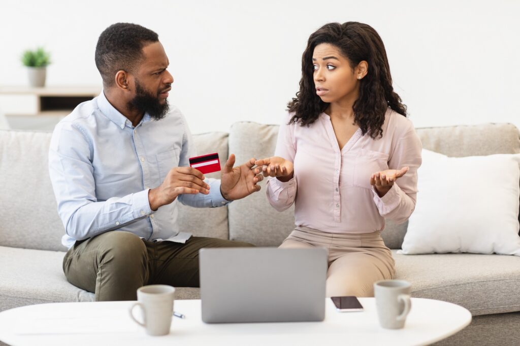 Couple sitting on the couch engaged in a tense exchange.