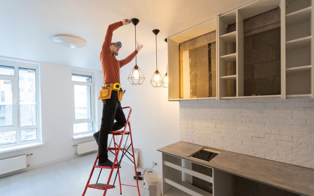 Person installing lights in a kitchen remodel