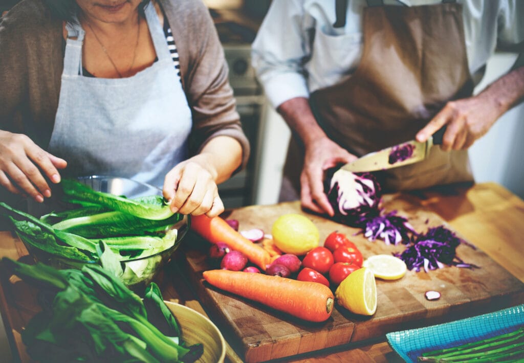 senior couple preparing fresh colorful vegetables in kitchen